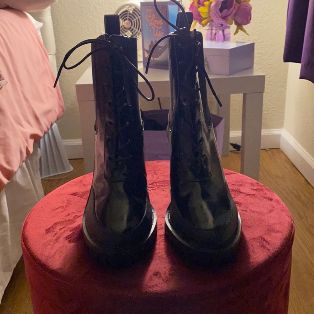 Black heeled combat style boots with lacing.